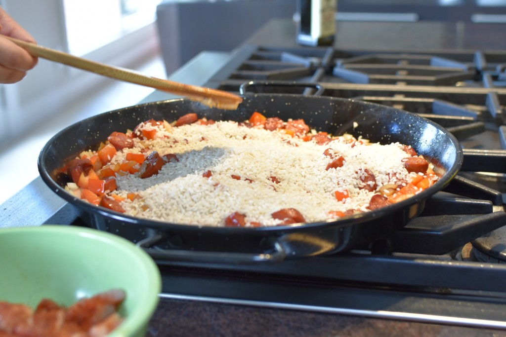 Adding paella rice