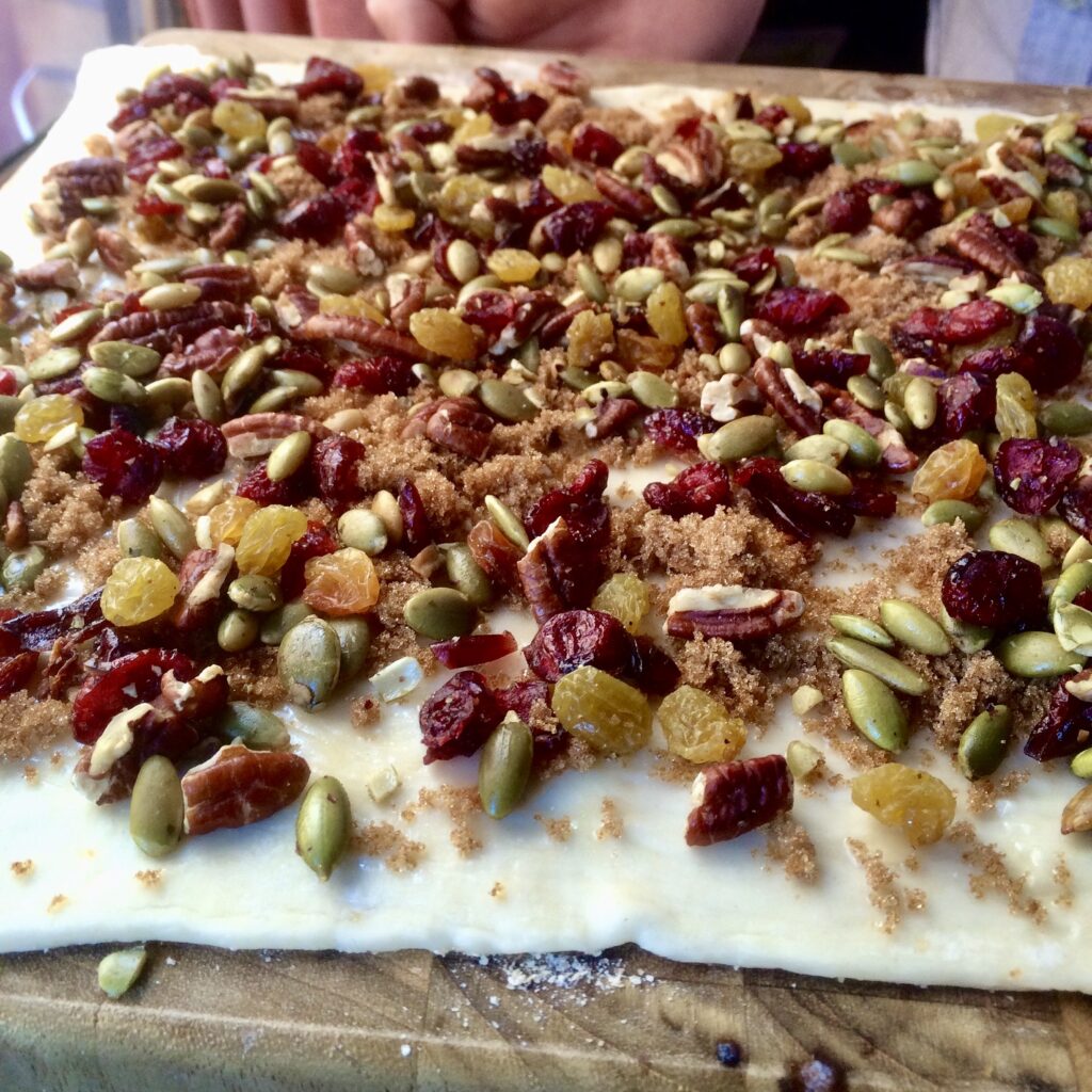 An abundance of nuts, seeds, and dried fruits on a pillowy sheet of puff pastry