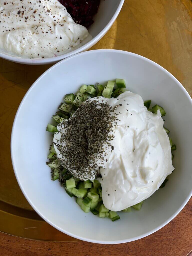 Chopped cucumber, dried mint, and creamy yogurt in a bowl ready to make Maast o Khiar