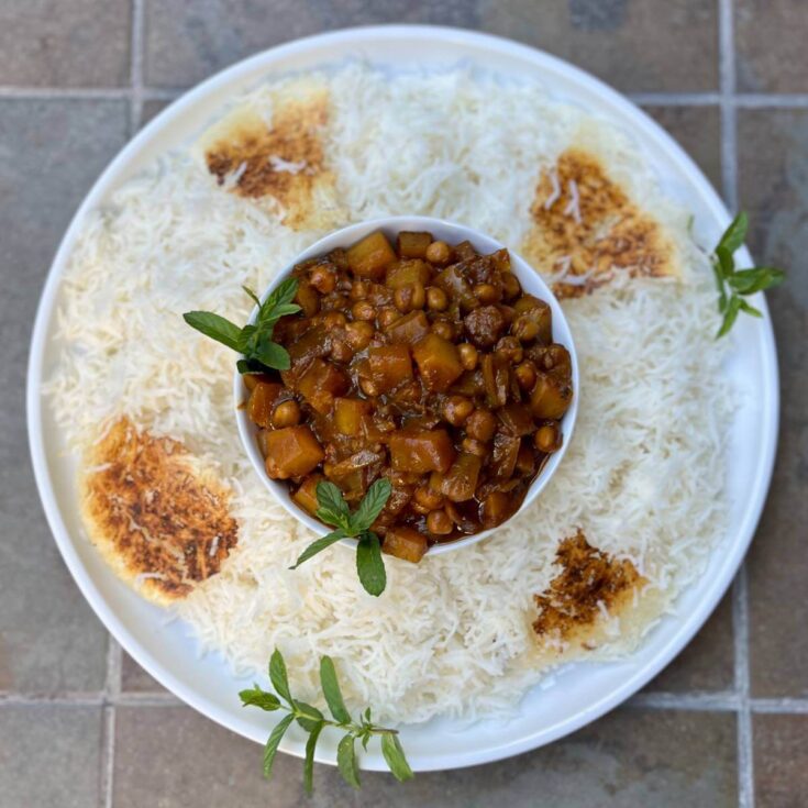 Close-up of Persian vegan Gheymeh made with chickpeas and potatoes, plated with saffron basmati rice and tahdig.