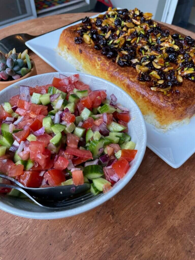 Colorful Salad Shirazi with crispy Tahchin topped with barberries and pistachios
