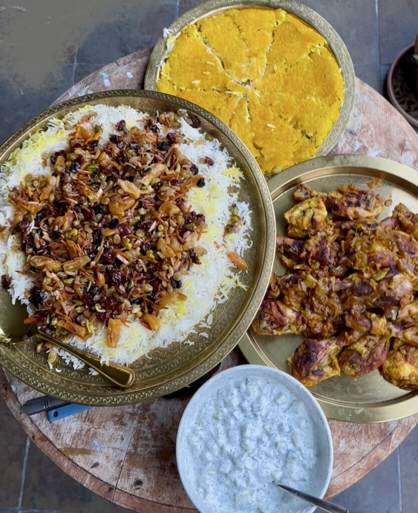 Colorful and delicious Persian Jeweled rice with braised chicken and saffron tahdig.