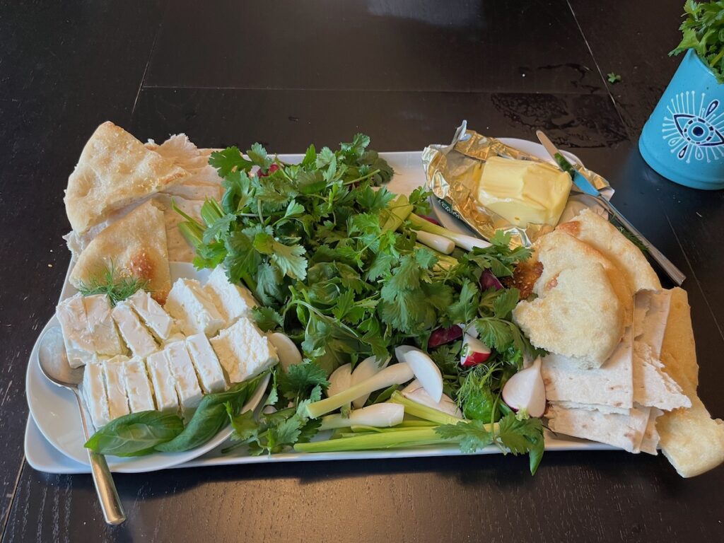 Sabzi khordan platter of fresh herbs with cheese, butter, and vegetables. Side or starter for Persian meal.
